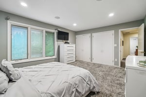 Another view of the second bedroom showing two-double door closets.
