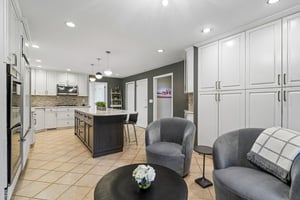 This alternative view reveals the true scale of the kitchen storage capacity. The bright breakfast area, currently styled with a cocktail table and chairs, easily accommodates a full-sized dining table for gatherings.