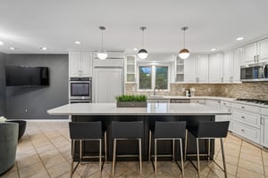 The heart of the home is a designer kitchen, featuring an oversized center island with seating that serves as the ultimate hub for daily life. From casual morning coffee to large scale holiday prep, the expansive workspace is perfectly positioned for both functionality and social connection.