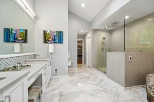 The beautiful ensuite bathroom rivals any designer spa, complete with a dedicated make-up vanity, custom cabinetry with double sinks and a spectacular oversized shower, and two huge walk-in closets - perfect for a peaceful start to your day. True luxury is felt as much as it is seen. The primary suite is enhanced by premium radiant heated floors, ensuring a warm and inviting atmosphere throughout the year.