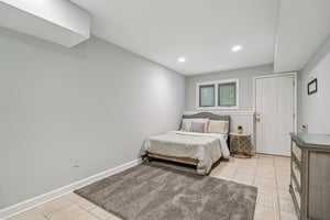 The lower level features a secluded fifth bedroom, perfect for guest or multi-family generational living. This bright and spacious suite offer a private door for direct access, ensuring independence and comfort in a quiet corner of the home.