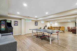 Spacious lower lower-level recreation room featuring dedicated areas for gaming, lounging, and entertaining. This bright, open-concept space offers limitless possibilities for oversized furniture, game tables and family gatherings.