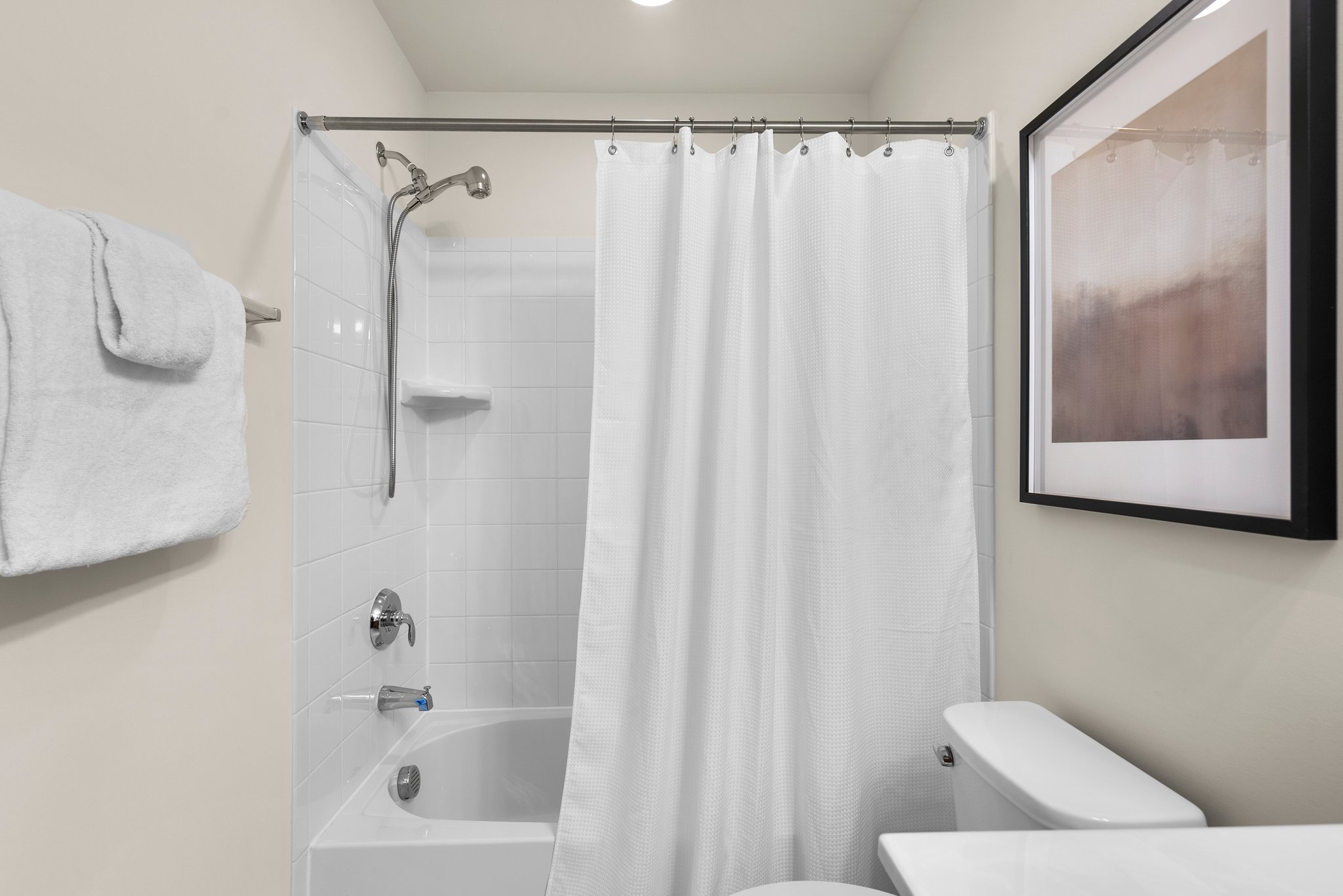 Clean & classic white tub & shower in hall bath