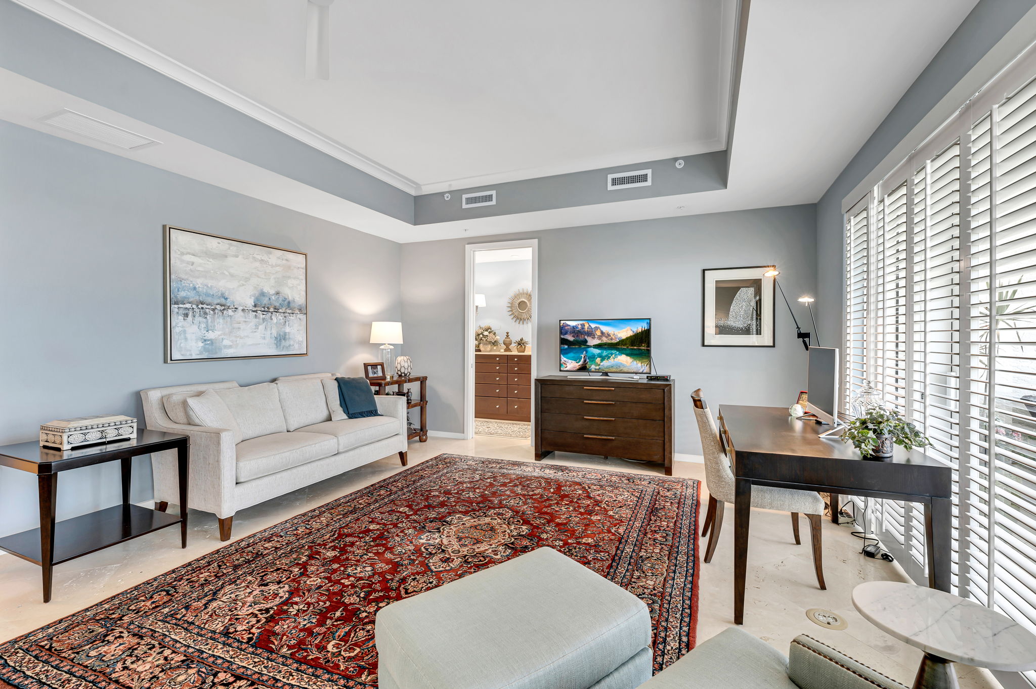 Primary bedroom with seating and office, coffered ceiling details and plenty of natural light!