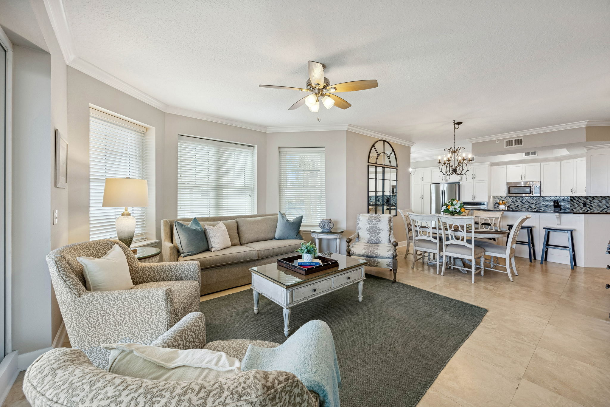 The open living areas are bright, spacious, and designed to flow seamlessly from gathering spaces to the remodeled kitchen beyond.