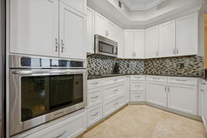 The kitchen features complementing custom cabinetry, granite counters, and stainless steel finishes ...