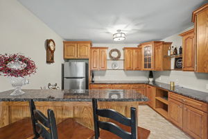 Wet bat with solid surface countertops, refrigerator, and dishwaher