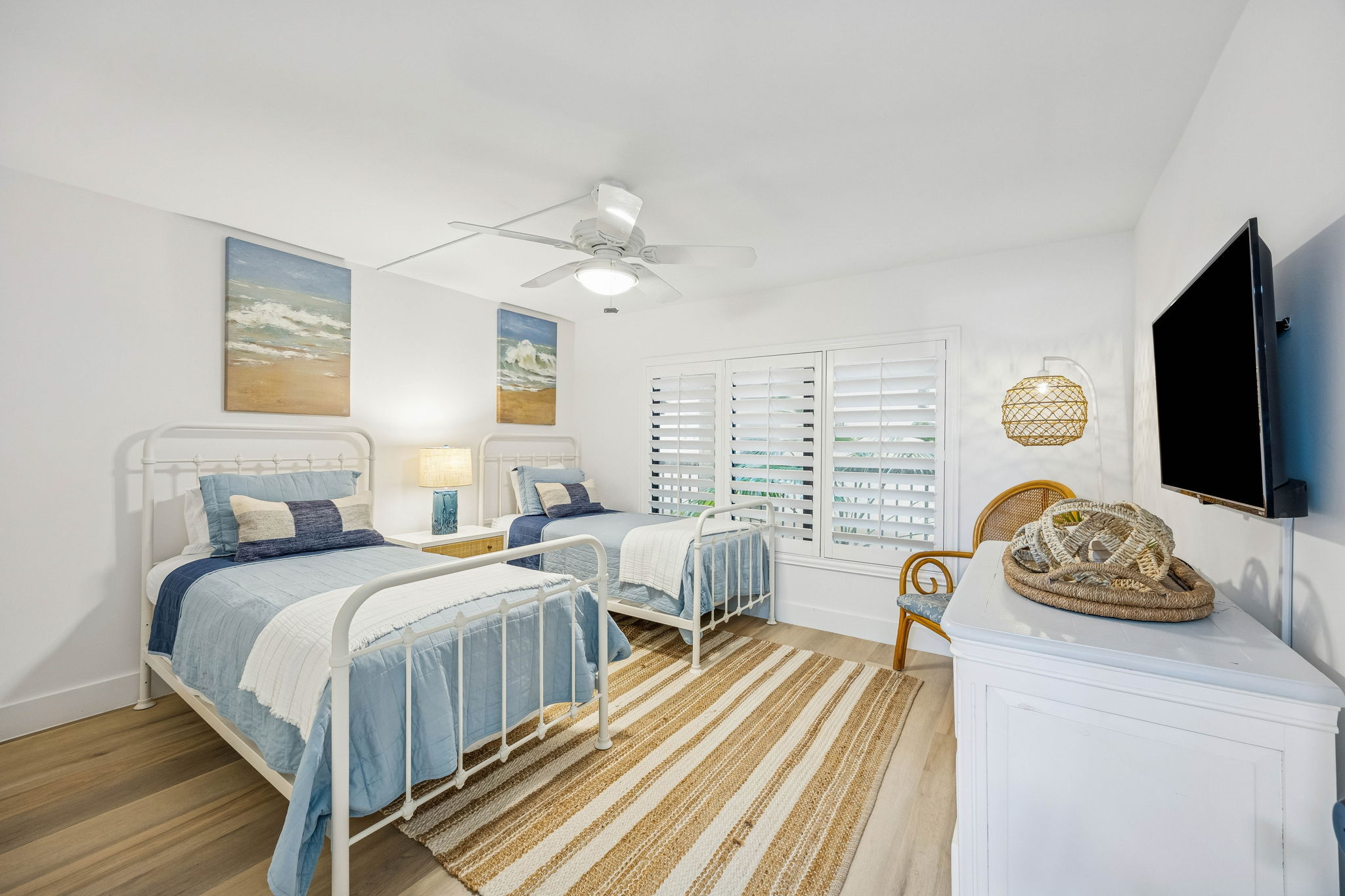 The guest bedroom continues the same bright, coastal character with twin beds and an easy layout ...