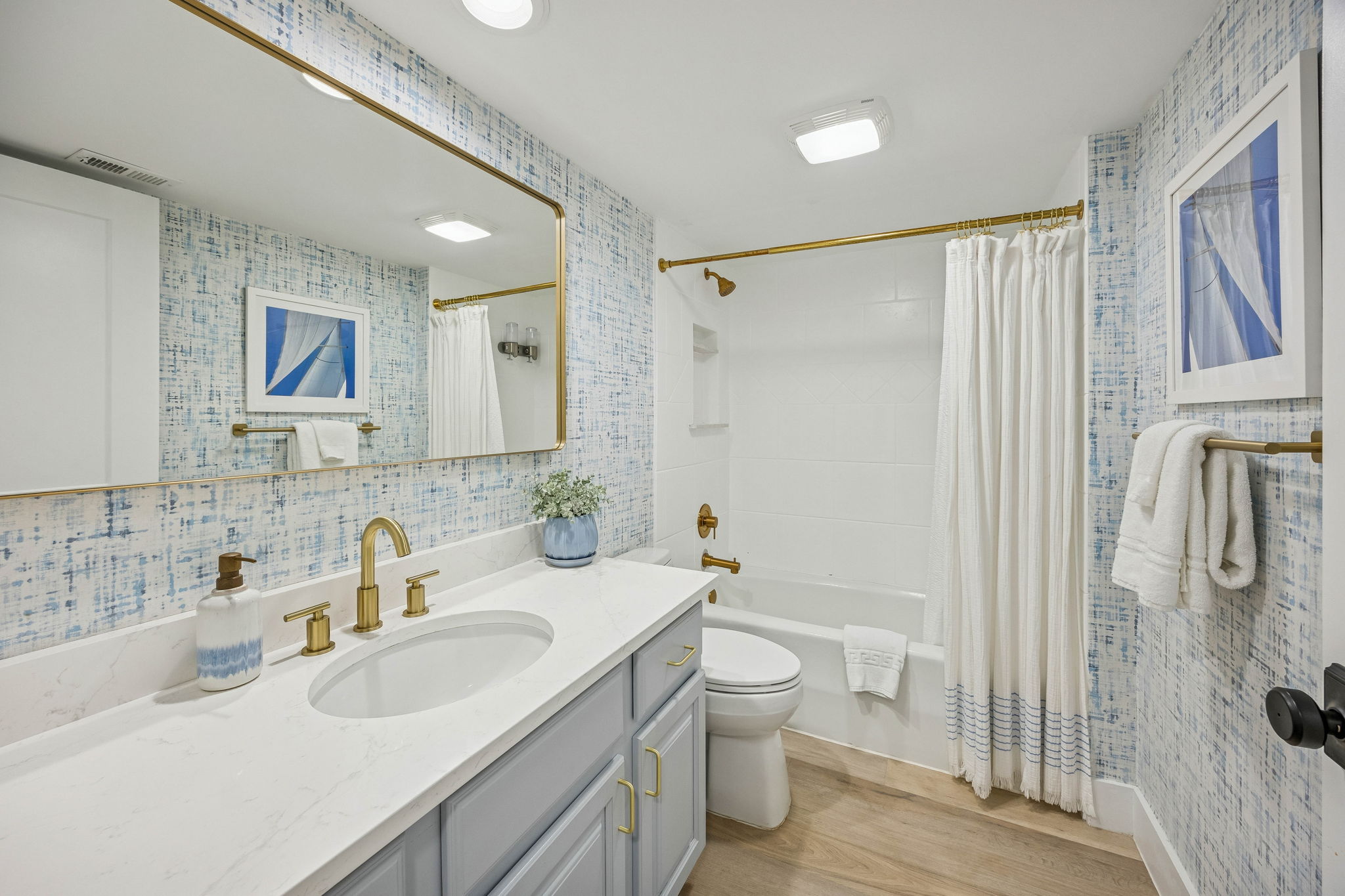 The guest bath adds another thoughtful layer of design, with fresh finishes and a tailored coastal look ...