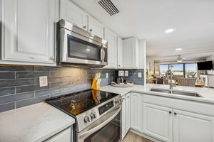 Blue tile adds contrast and personality, while the open layout keeps the kitchen connected to the living area beyond ...