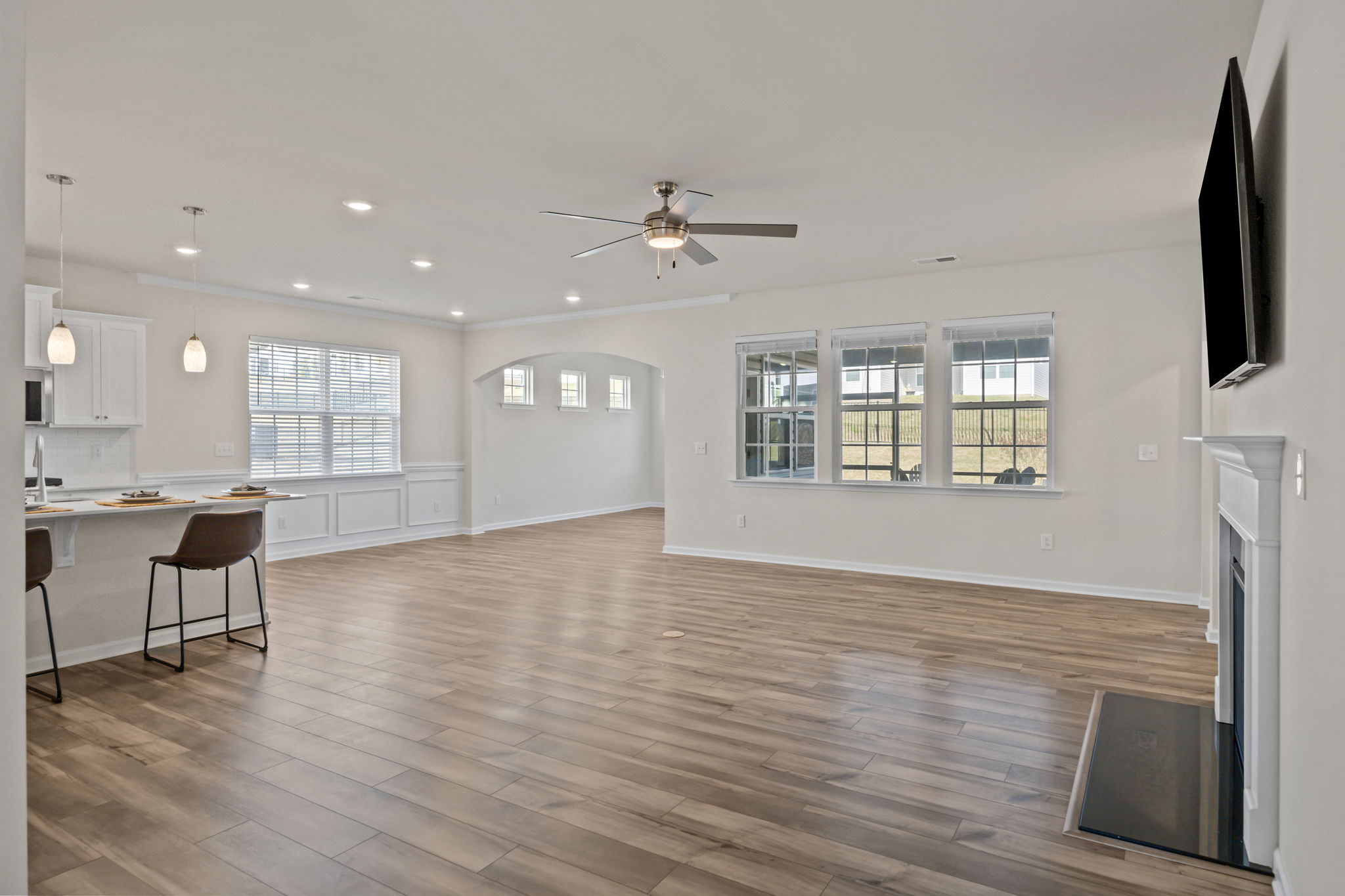 Expansive great room and dining area with recessed LED lighting, an arched entry to dining/keeping room area, fireplace and wall-mounted TV.  Upgraded ceiling fans throughout.  Marble hearth.