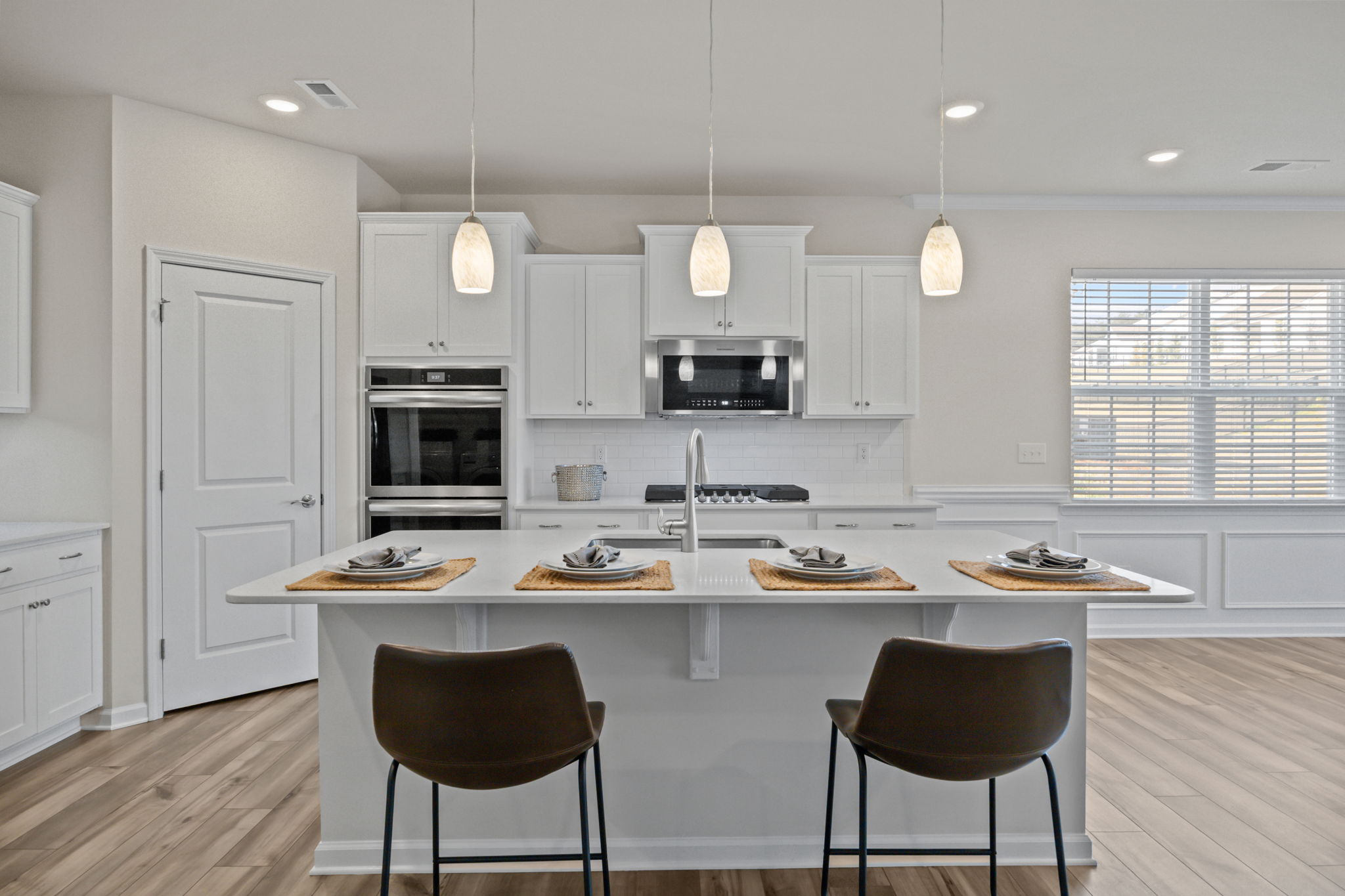 This magnificent island draws you in to enjoy the kitchen space and visit a while longer!  The neutral decor, drop down pendant lighting and GOURMET upgrade in appliances speak quality.