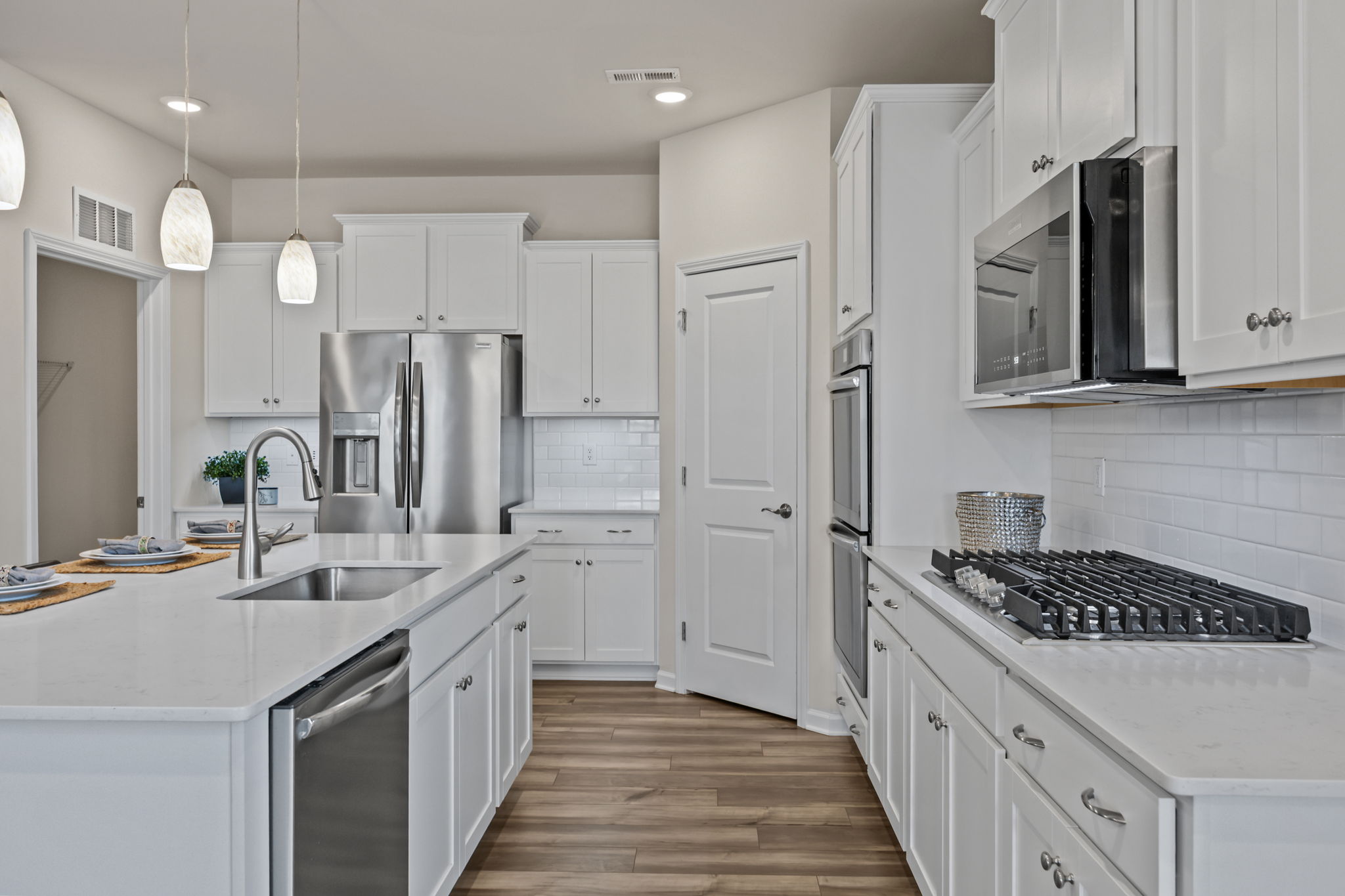 Lots of room! Thoughtfully designed with large stainless sink and pull down sprayer near island dishwasher.  GOURMET UPGRADE PACKAGE.  Custom built-in gas range!