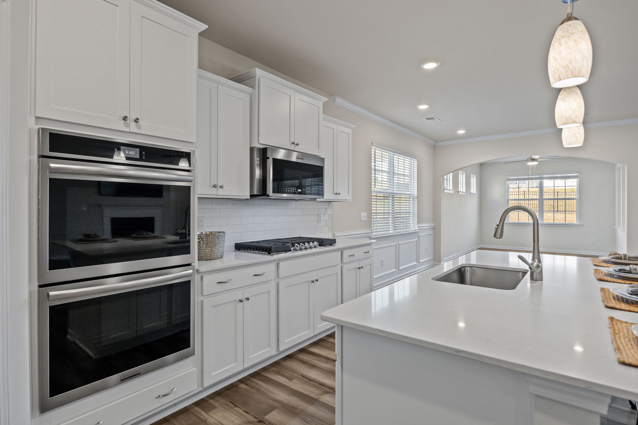 Full view from kitchen to breakfast/keeping room area with custom moldings and architectural design.  Notice the clerestory windows which give light yet provide privacy.  Entry door to the fully screened, covered back porch makes entertaining easy!