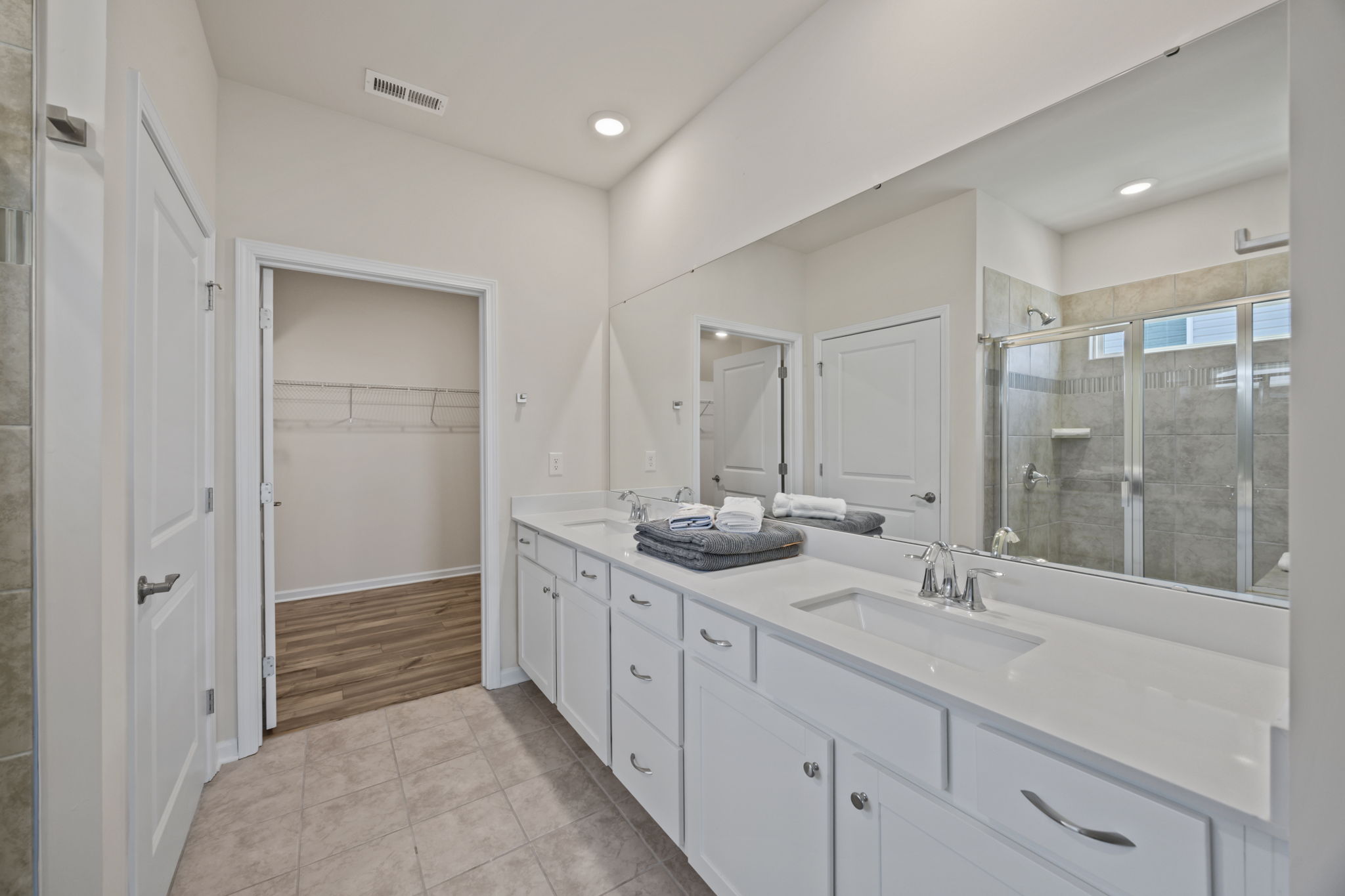 PRIMARY ensuite full bath with long quartz countertop featuring popular squared sinks and loads of room.  Doored toilet facility, tiled floors and ample sized shower.  Expansive closet!   Enjoy!