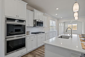 Full view from kitchen to breakfast/keeping room area with custom moldings and architectural design.  Notice the clerestory windows which give light yet provide privacy.  Entry door to the fully screened, covered back porch makes entertaining easy!