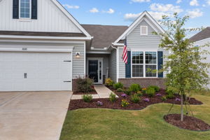 Graceful landscaped beds and welcoming covered entry.