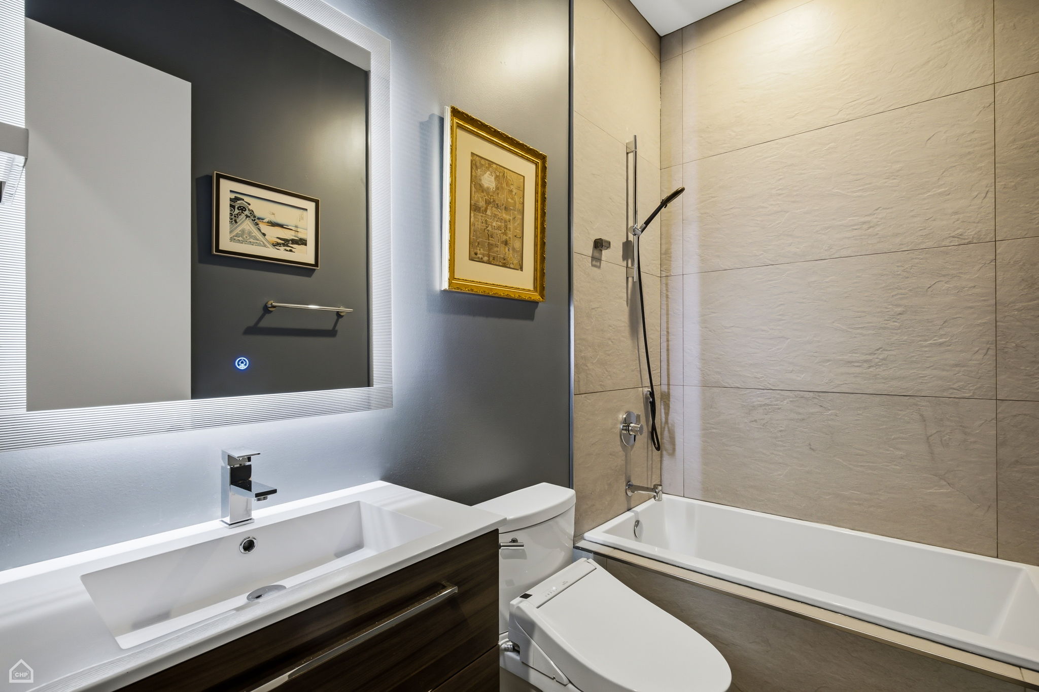 Second full bath is warm yet sleek with serene lighting and a deep soaking tub