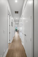 Long hallway lends privacy to primary bedroom en-suite