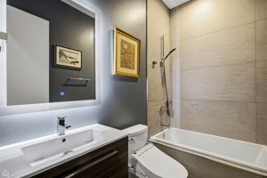 Second full bath is warm yet sleek with serene lighting and a deep soaking tub