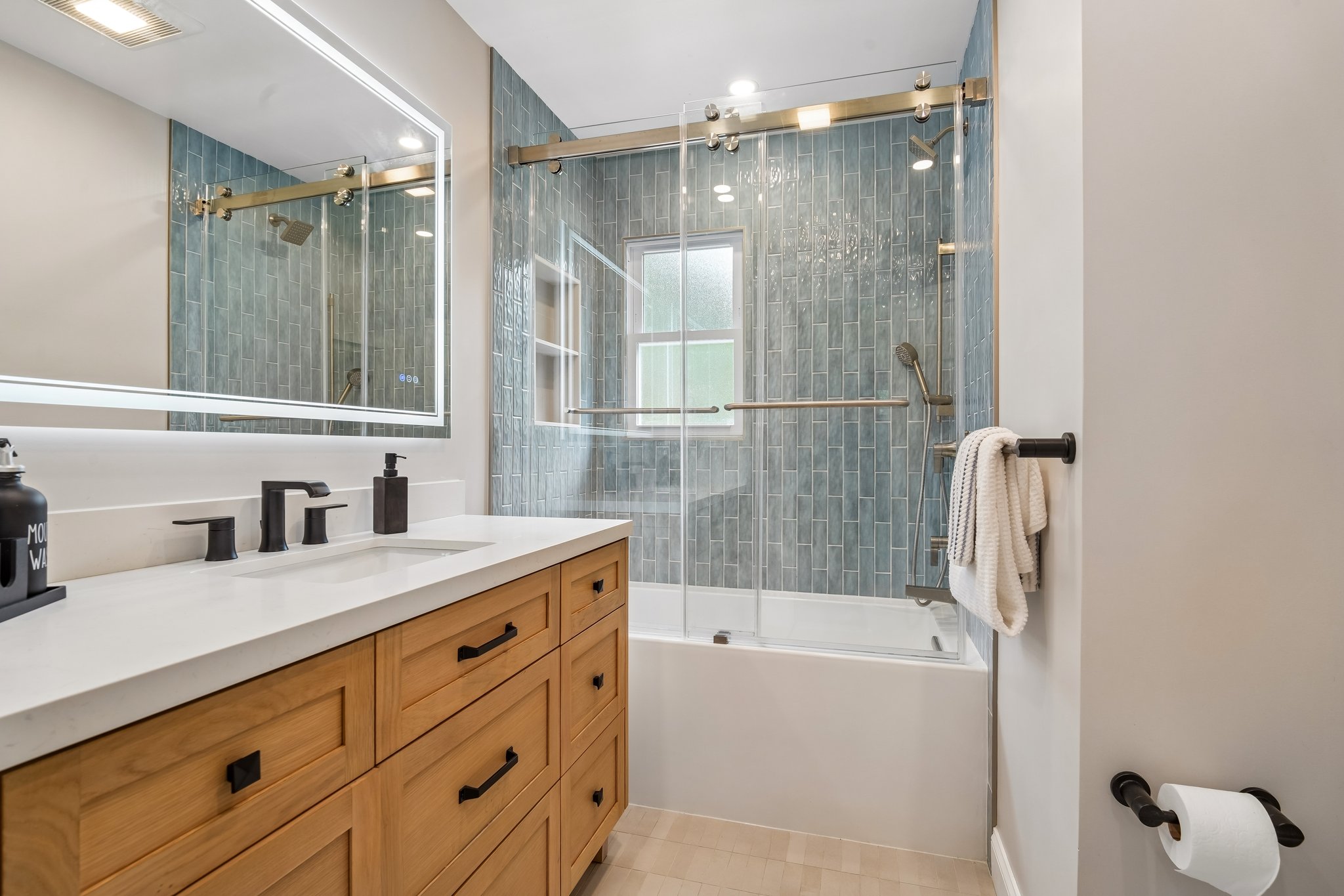 Updated Hall Bath with soaking tub, furniture style vanity with quartz countertops