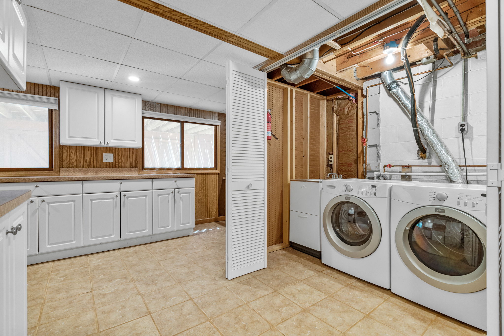 Laundry Room with ceramic tile and plenty of cabinetry