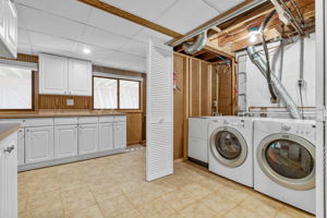 Laundry Room with ceramic tile and plenty of cabinetry