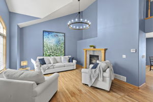 This front room with new lighting, double sided fireplace, great natural light and vaulted ceilings welcomes you home.
