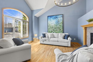 This front room with new lighting, double sided fireplace, great natural light and vaulted ceilings welcomes you home.