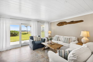 Note the the wood plank ceilings, shiplap wall, and soft sand color palette, all of which add to the breezy, beachy feel of the living area...