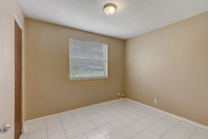 Guest bedroom two with tile floors and reach-in closet