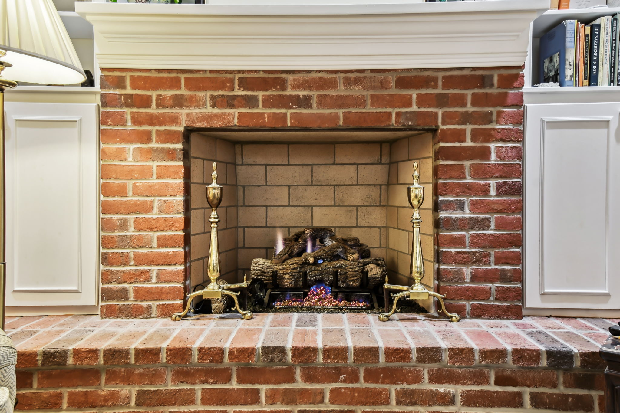 Beautiful brick hearth is flanked by cabinetry