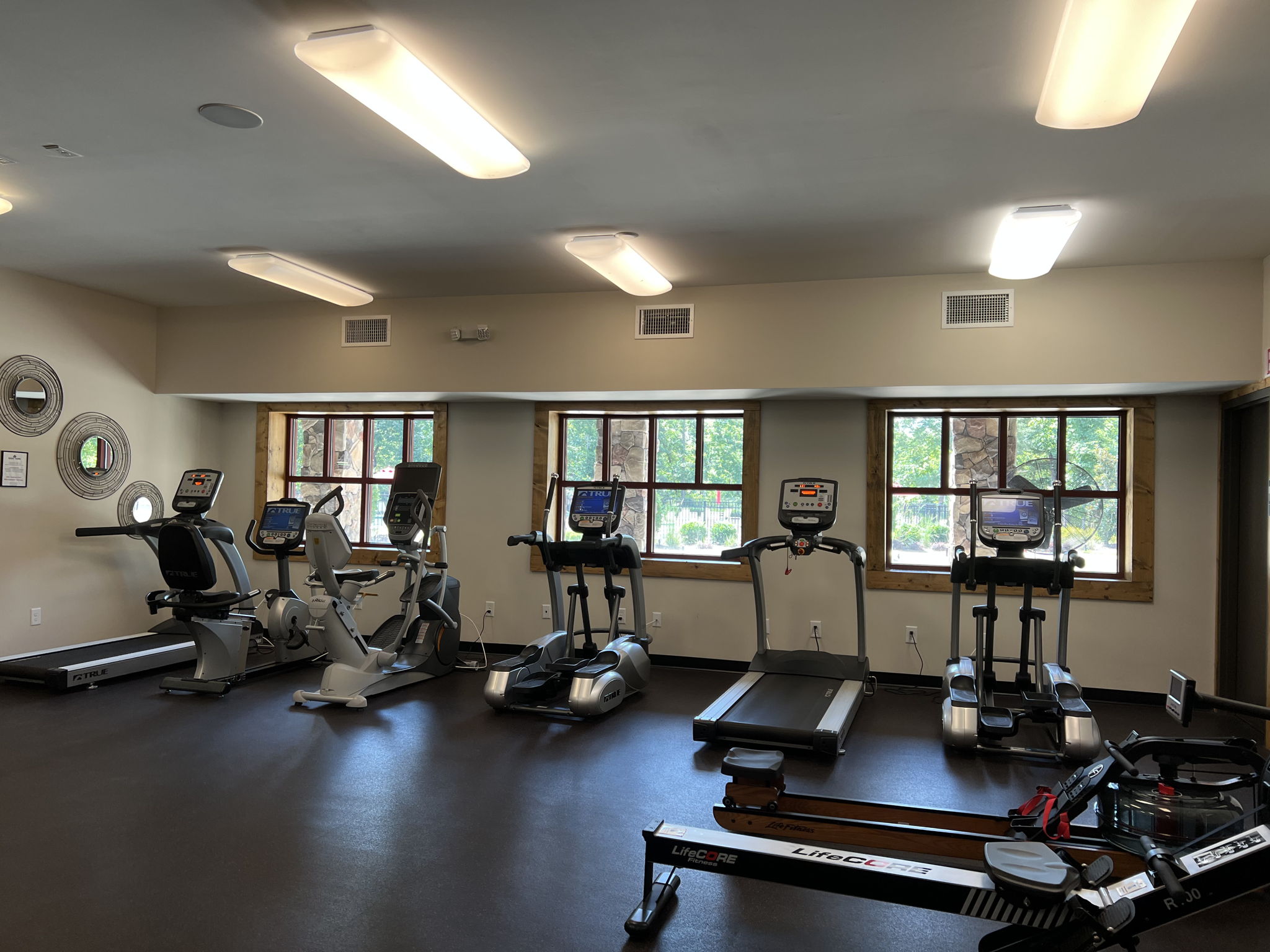 Fitness Center on lower level of Tree Tops clubhouse with exercise machines, weights, and room for exercise classes.