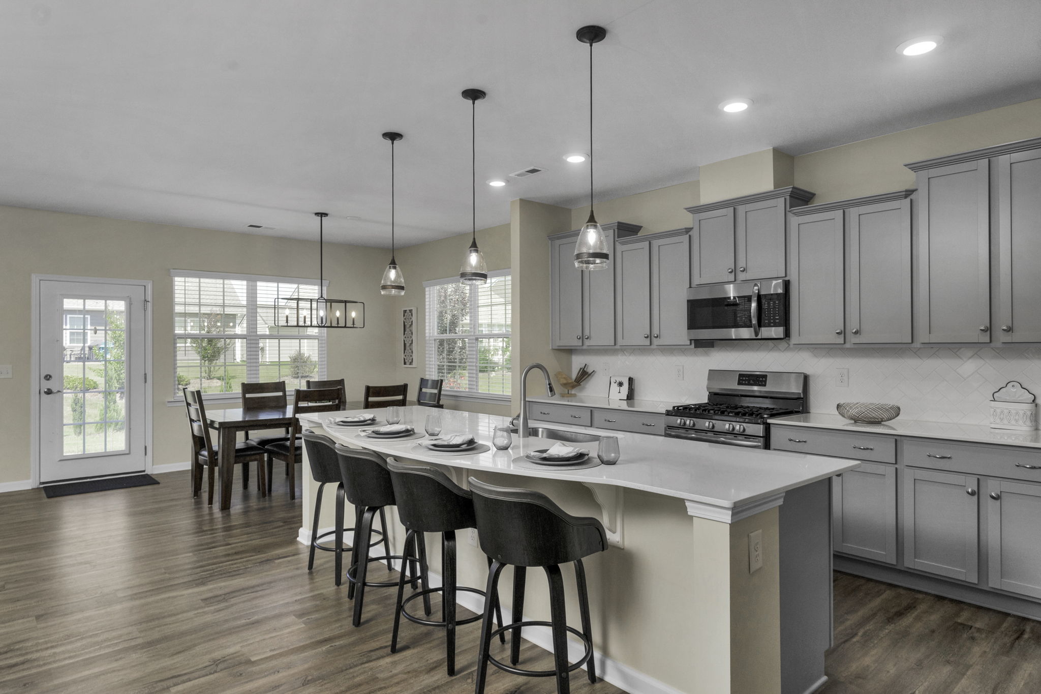 Spacious Kitchen with oversized quartz island, stainless steel appliances and walk in pantry.