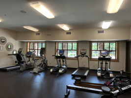 Fitness Center on lower level of Tree Tops clubhouse with exercise machines, weights, and room for exercise classes.
