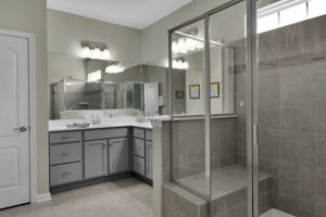 Primary Bathroom including double bowls, large shower with bench, linen closet, water closet and large walk in closet.