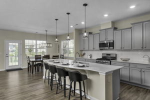 Spacious Kitchen with oversized quartz island, stainless steel appliances and walk in pantry.