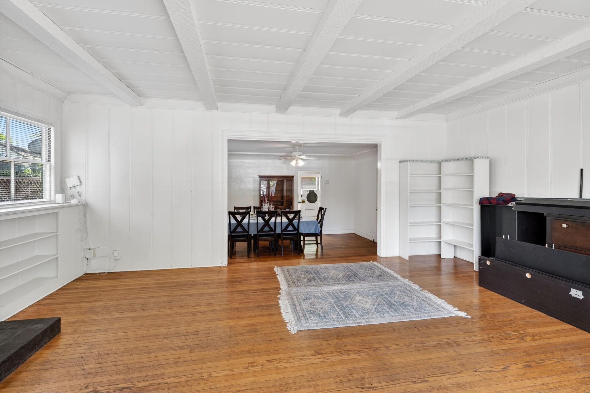 The living room with the dining room and kitchen entrance in the background.