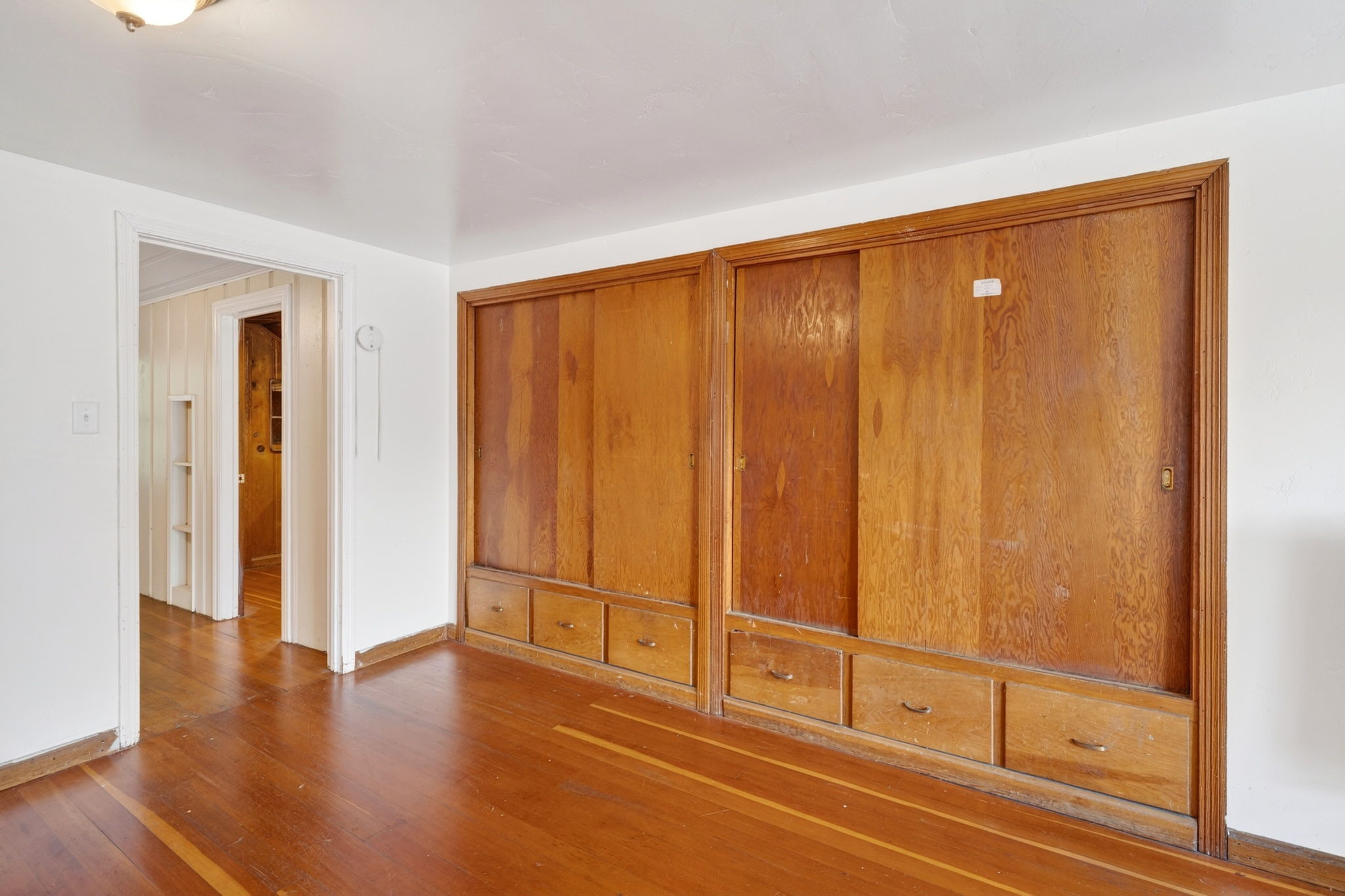 The primary bedroom with built in closets and drawers.  The sitting room is to the left.