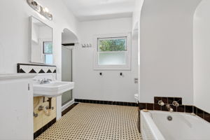 The downstairs bathroom.  There is a bathtub to the right and a shower stall to the left in the background.