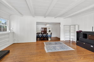 The living room with the dining room and kitchen entrance in the background.