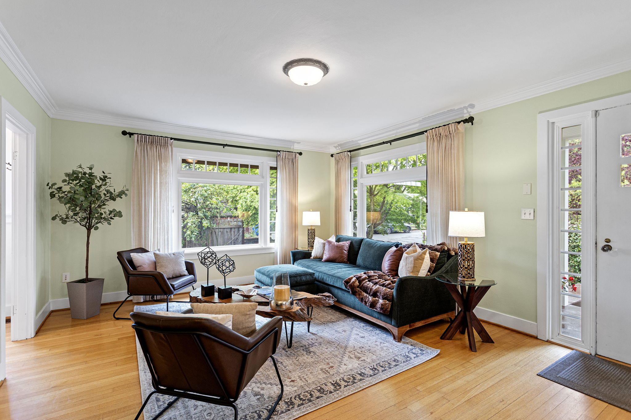 Large windows frame the greenery outside, blurring the line between the refined interior and the tended gardens.