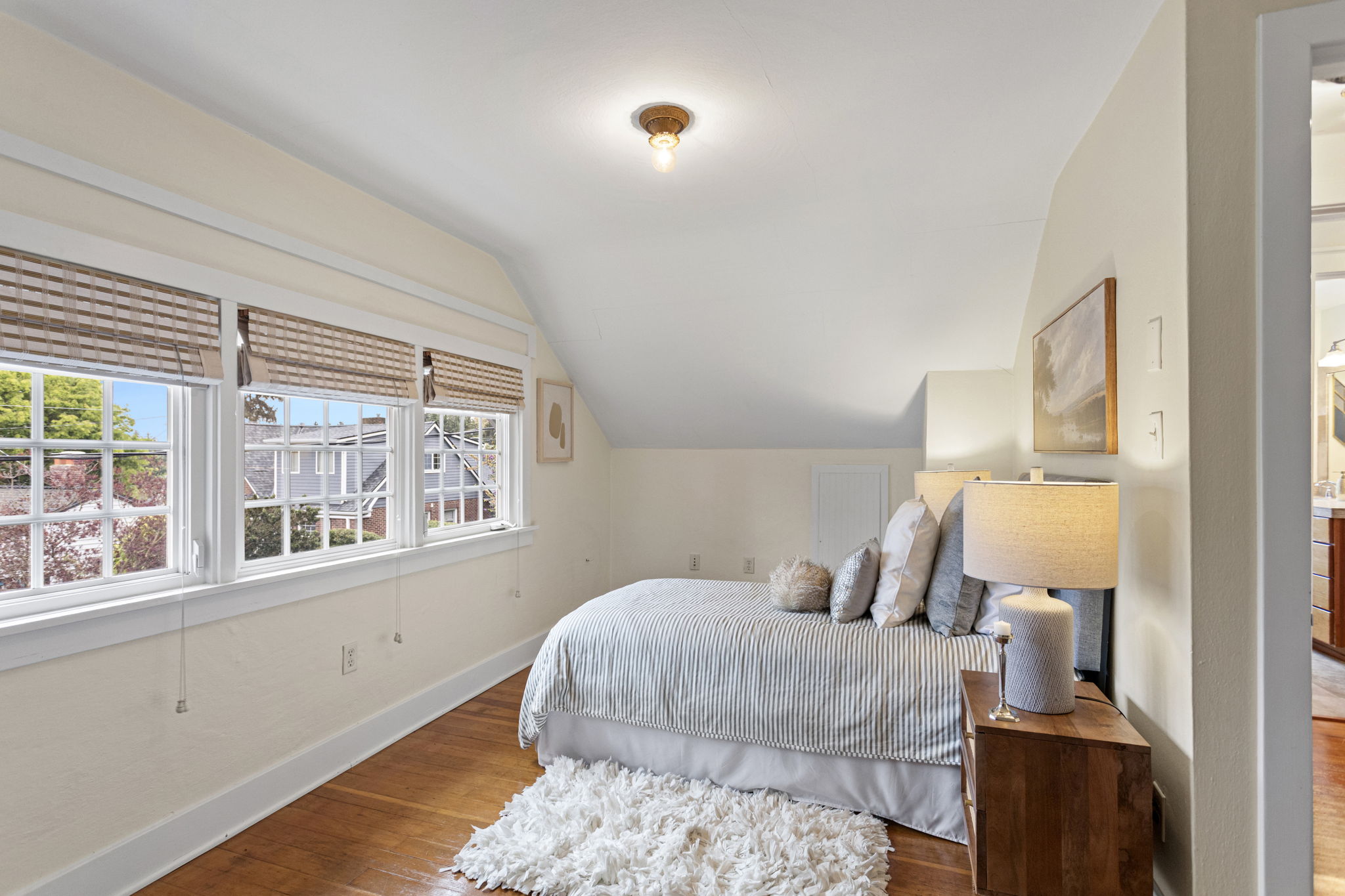 The roofline angles in. The triple window bank angles back. Original red fir floors run straight through. Nobody lost anything up here.