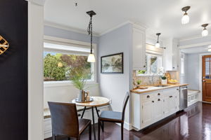 The eating nook tucks in beside the sink — built-in bench, pendant light, east-facing window. Practical and considered in equal measure.
