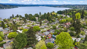 The Seward Park Life: Looking east over the canopy toward the shimmering expanse of Lake Washington. This hilltop retreat is just a short stroll from the hidden gem of Martha Washington Park, the shoreline at Pritchard Island Beach, and the iconic 300-acre forest and trails of Seward Park itself.