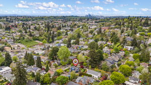 Iconic Northwest Context: A sweeping perspective looking northwest toward the Seattle skyline. This view anchors the historic 1924 Craftsman within the organic, winding character that defines South East Seattle—balancing the pulse of the city with the quiet, park-lined streets that lead home.