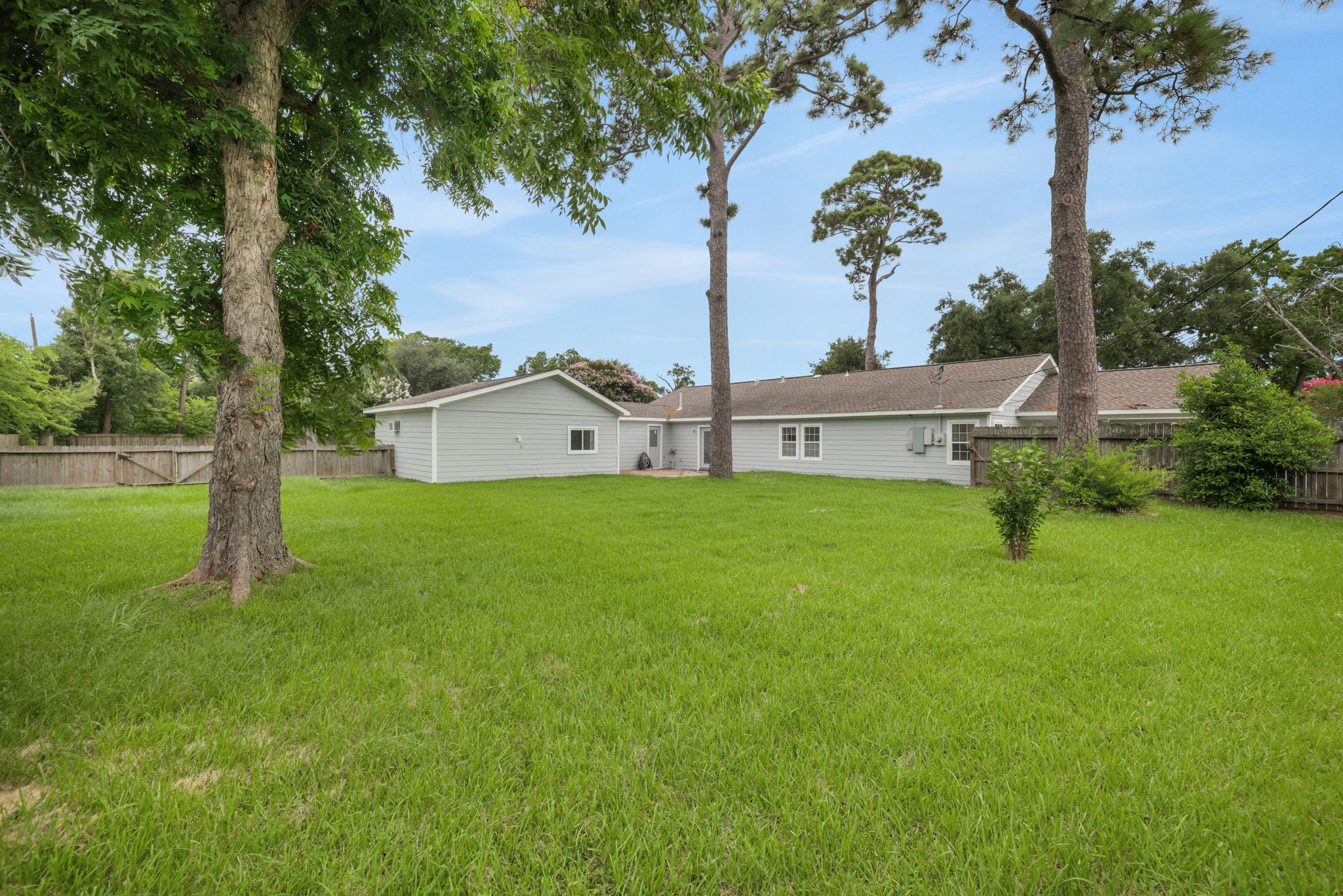 Spacious backyard featuring a lush green lawn and mature trees, offering ample space for outdoor activities. Are you ready to escape the hustle and bustle of city living?