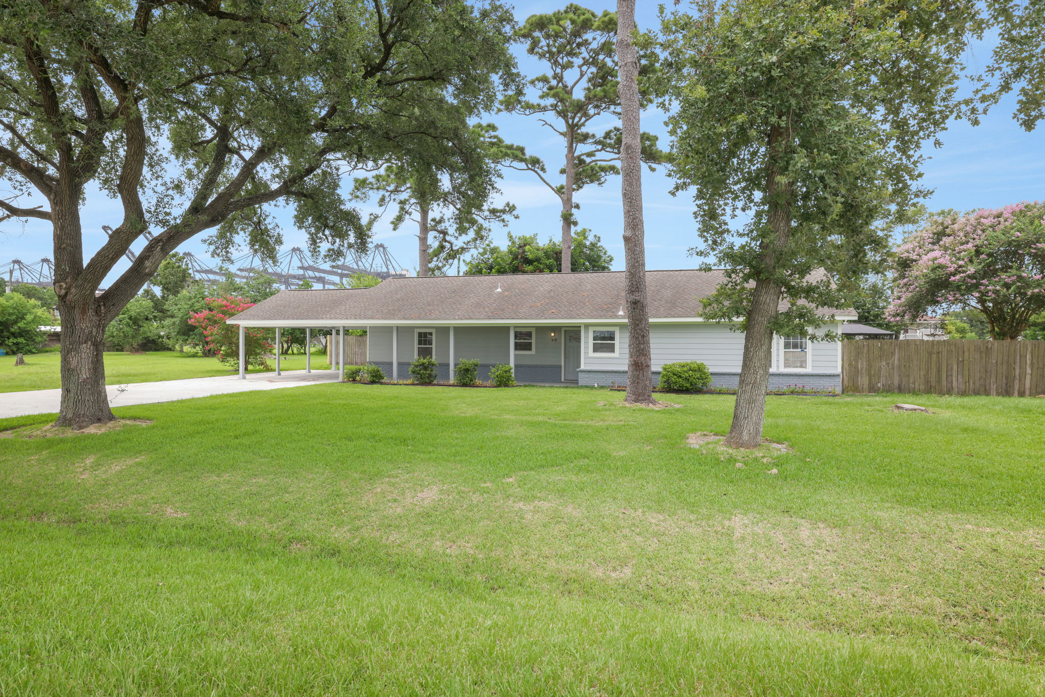 Bay Area single-story home with a spacious front lawn and mature trees. Features a covered carport, a welcoming front porch, and a fenced backyard. Ideal for those seeking a serene, suburban setting.