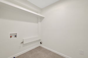 Clean, empty laundry room with hookups for a washer and dryer