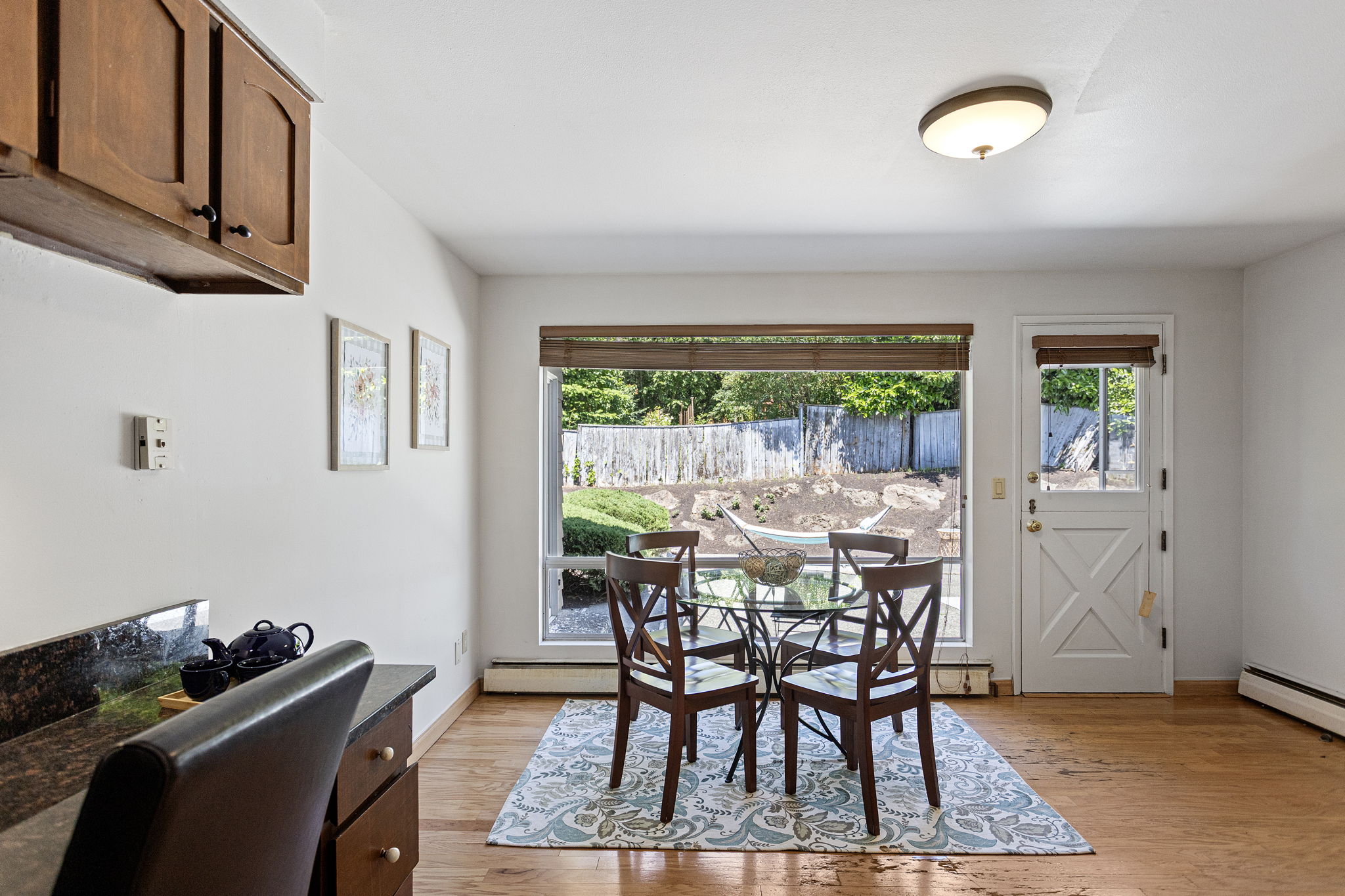 Second dining area with picture window to the back patio, exterior door, and a built-in desk in the corner.